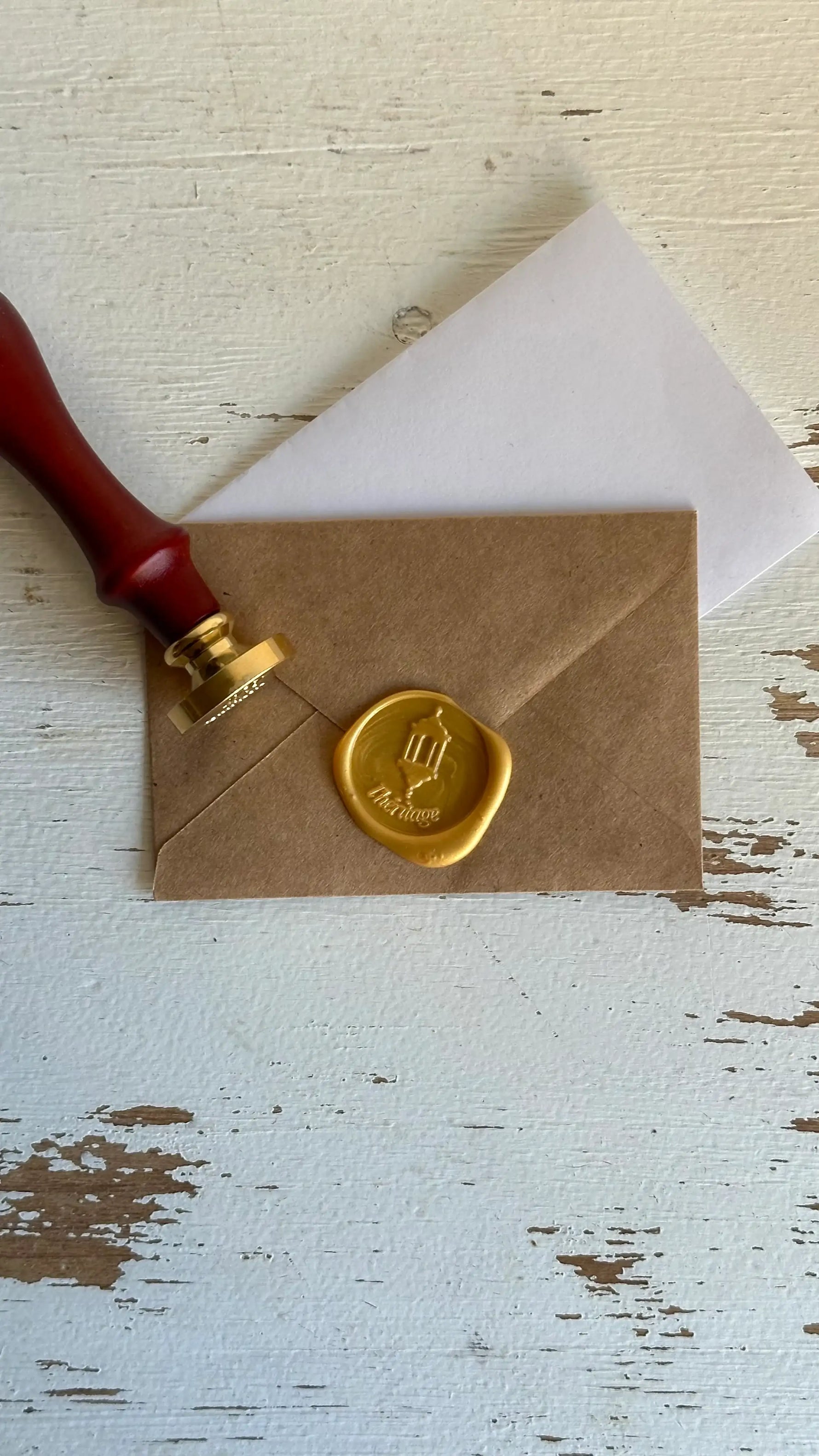 Enveloppe kraft cachetée à la cire dorée, timbre en bois, papeterie islamique élégante.