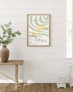 Affiche décorative islamique avec citation coranique en arabe et en français, sur mur blanc, vase en terre cuite et lanterne blanche, déco intérieure moderne.