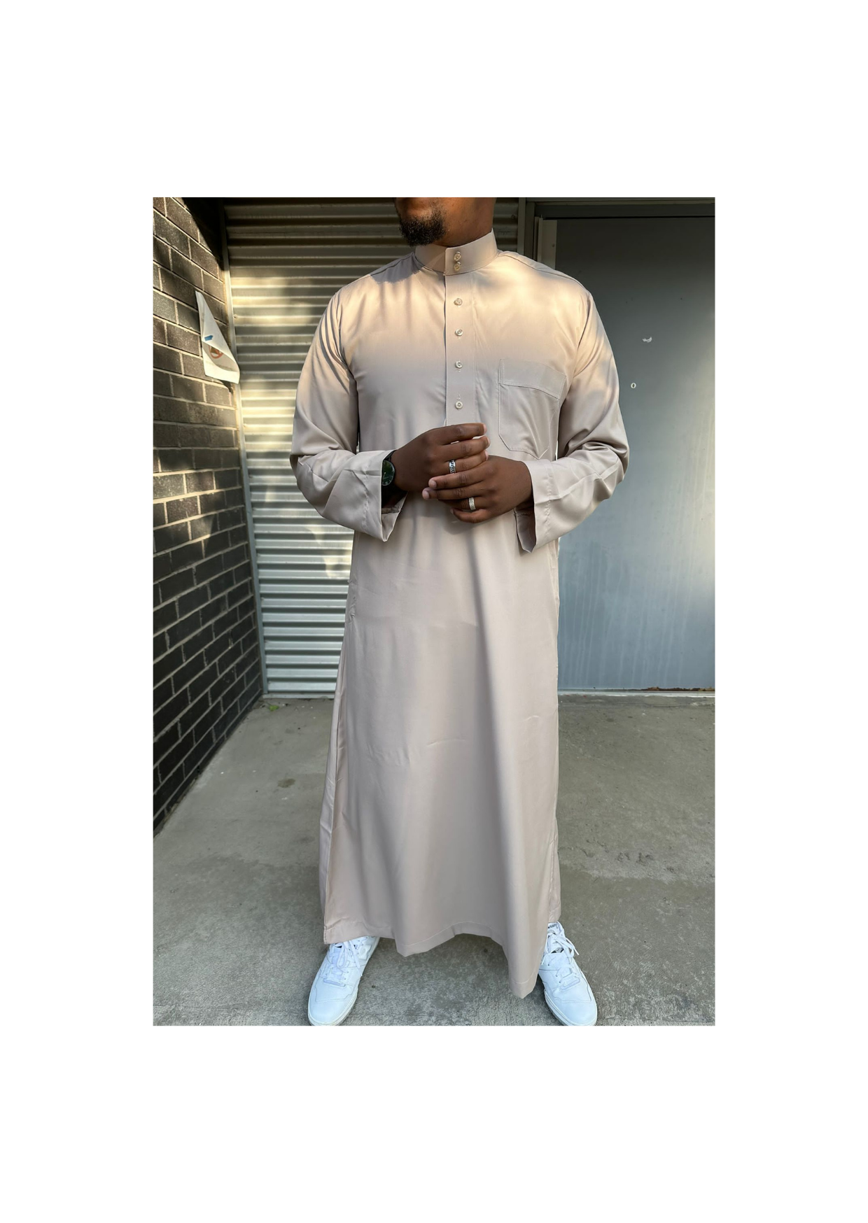 Homme portant un qamis saoudien couleur sable à manches longues, avec col officier et boutons, offrant un style élégant et raffiné.