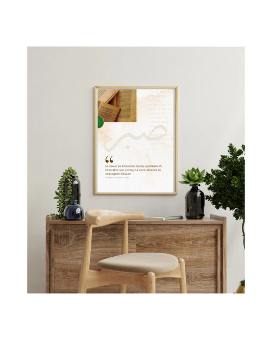 Affiche murale encadrée avec citation islamique en français, posée au-dessus d’un bureau en bois clair décoré de plantes vertes.