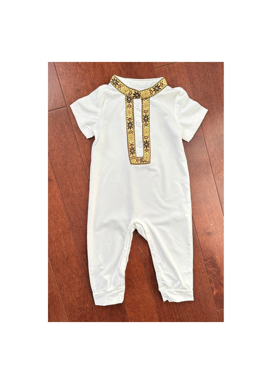 Combinaison traditionnelle blanche pour bébé, ornée d'un col et d'une patte de boutonnage brodés en doré et marron.

