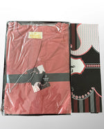 Qamis rouge plié dans un emballage transparent avec boîte noire et motifs rouges et blancs, marque MOJ.

