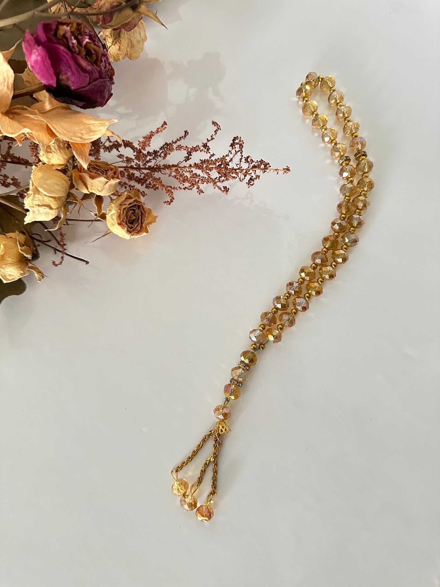 Tasbih musulman en perles de cristal dorées, 33 billes, séparateurs métalliques, cordon tressé or, fond floral décoratif