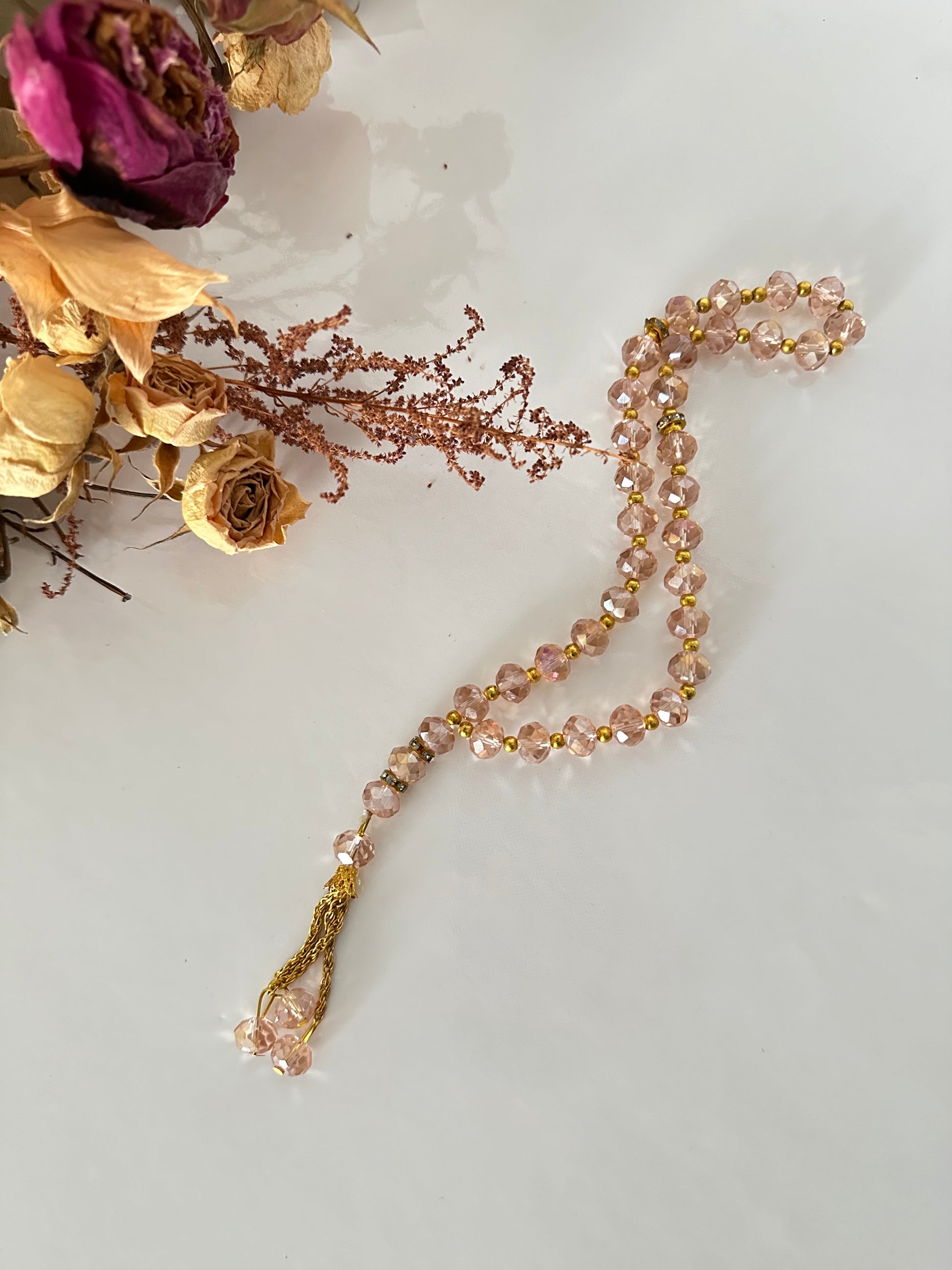Tasbih musulman en perles de cristal roses, 33 billes, séparateurs dorés, cordon tressé or, fond décoratif